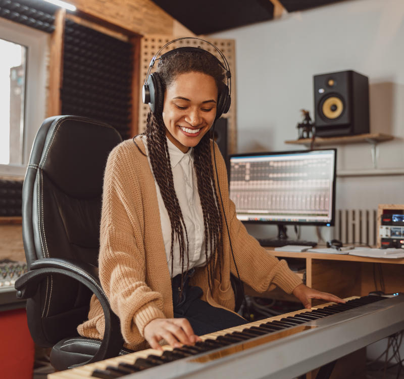 Frau spielt Keyboard im Tonstudio