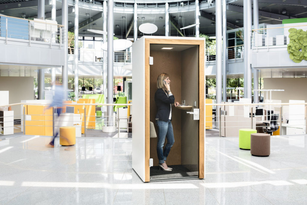 Frau telefoniert in einer Telefonbox