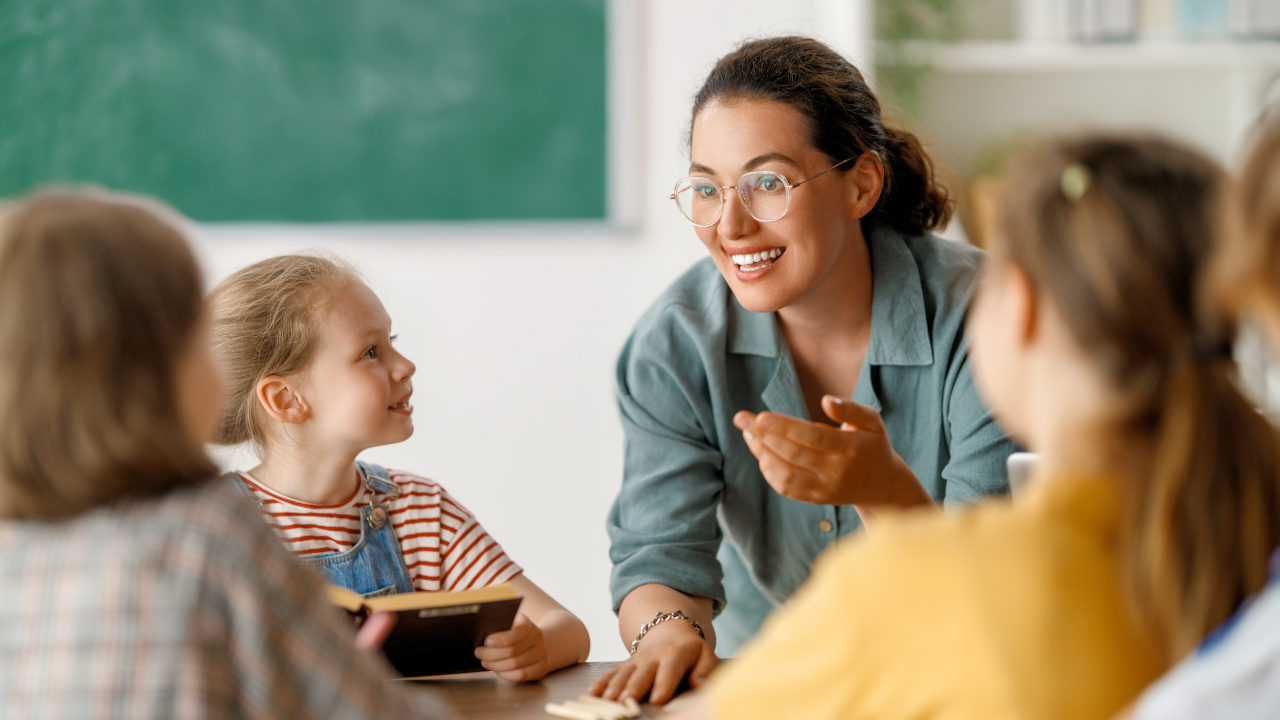 Lehrerin spricht mit Schülern in einem Klassenzimmer