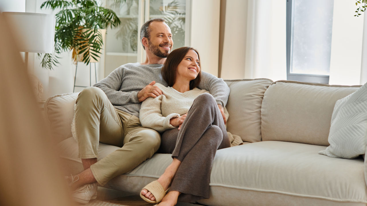 Paar sitzt zuhause auf dem Sofa